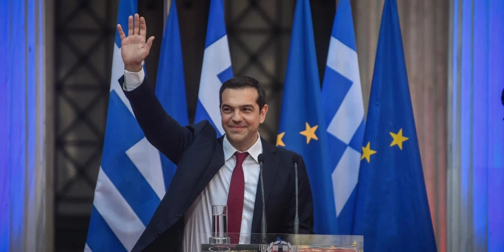 «Ρόδα, τσάντα και γραβάτα»: Πώς η Εφημερίδα των Συντακτών επικρίνει το σόου Τσίπρα